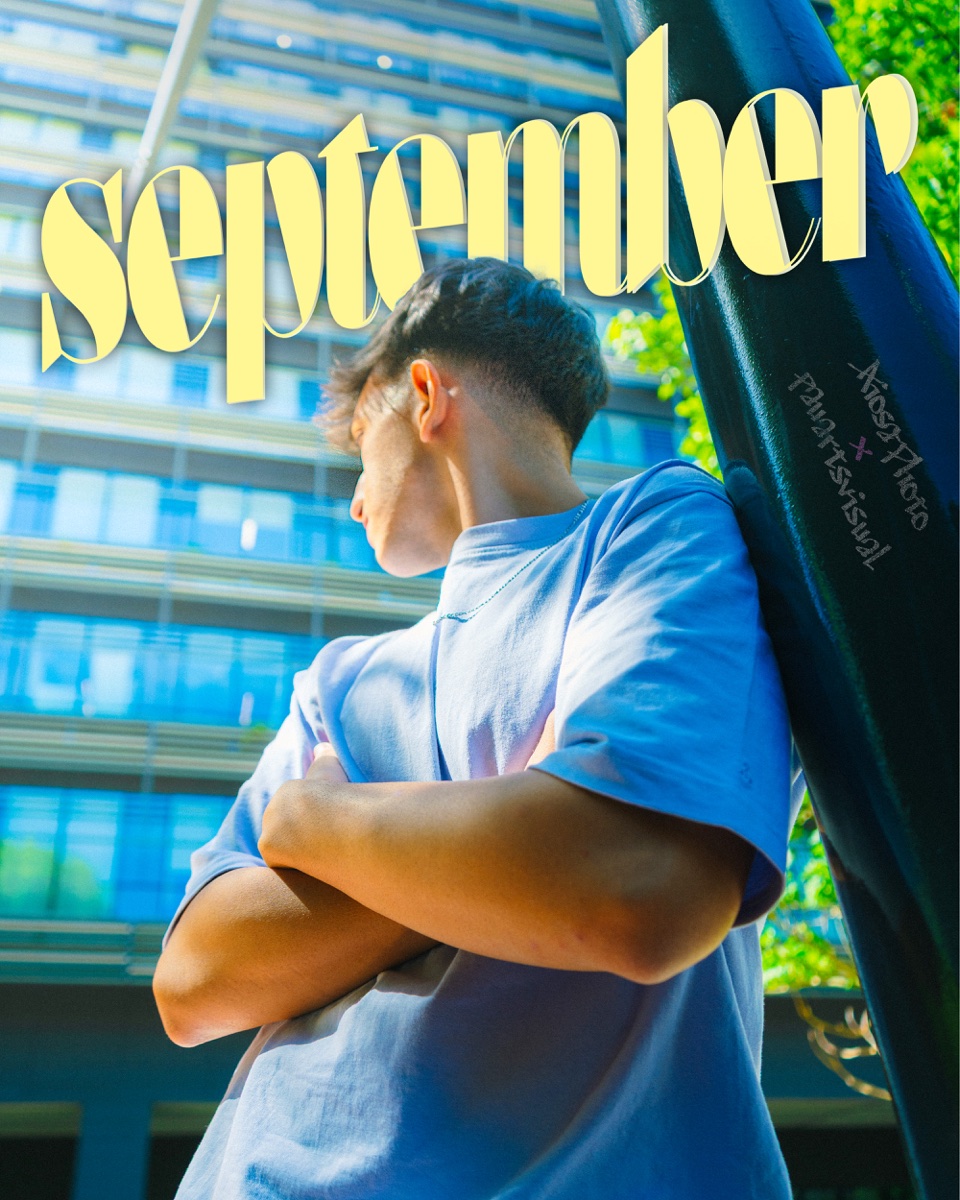 Retrato de un chico con camiseta azul apoyado en una columna